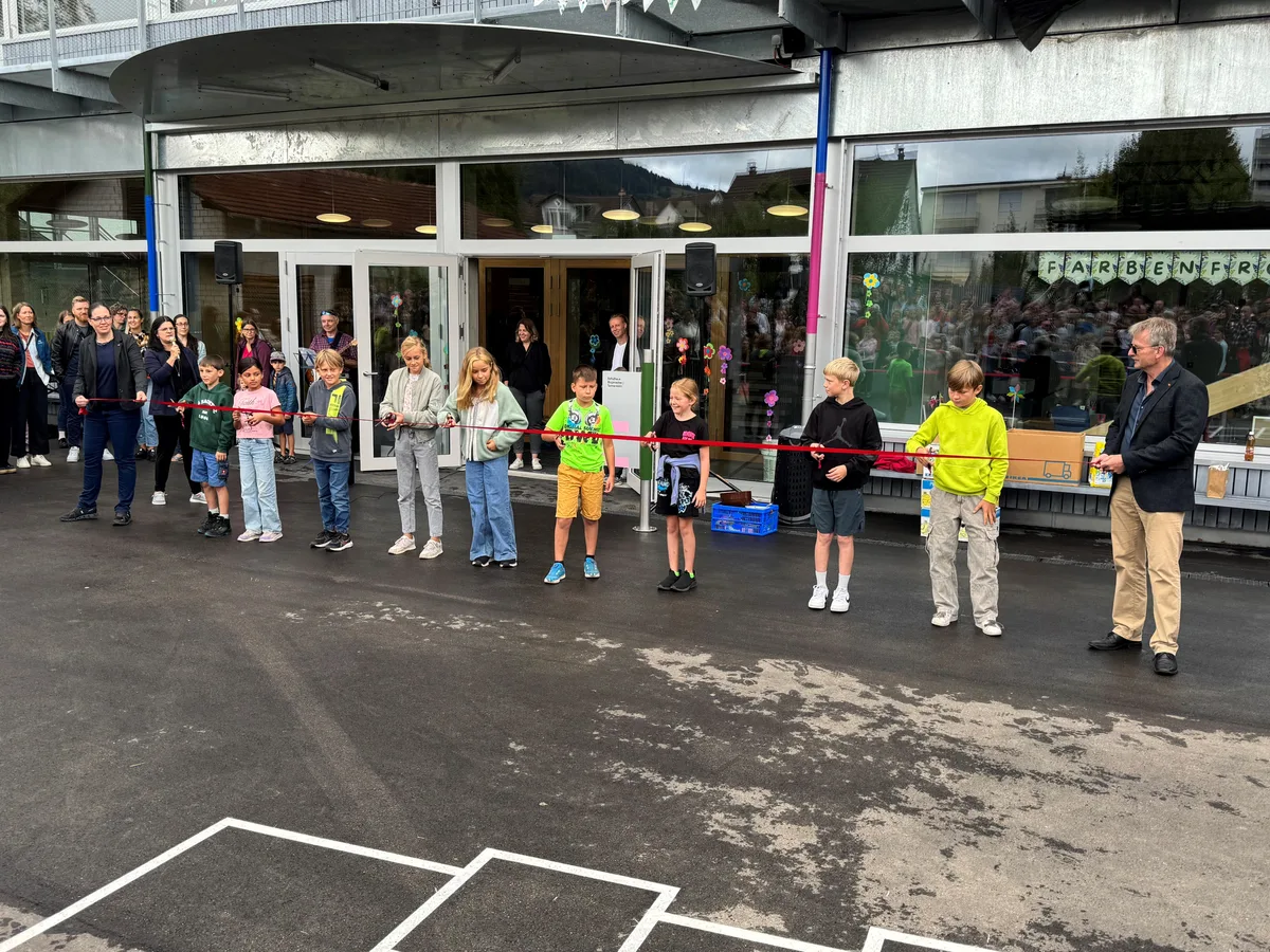 Man sieht Schüler, die das Schulhaus eröffnen.